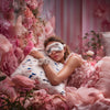 Lifestyle image featuring Glampton’s butterfly-print satin sleep set, including satin pillowcases, a matching eye mask, and satin scrunchies, styled in a pink floral bedroom setting.