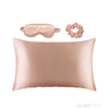 Glampton satin sleep set in peach, including a satin pillowcase, matching satin eye mask, and satin scrunchie.