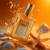 Glampton Vanilla Sun Musk Shimmer Fragrance Mist bottle leaning in golden sand with a starfish and seashells, surrounded by sparkling light on a warm sunset background.