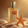 Glampton Vanilla Sun Musk Shimmer Fragrance Mist bottle on golden sand with a textured starfish and seashell, glowing under warm sunlight.